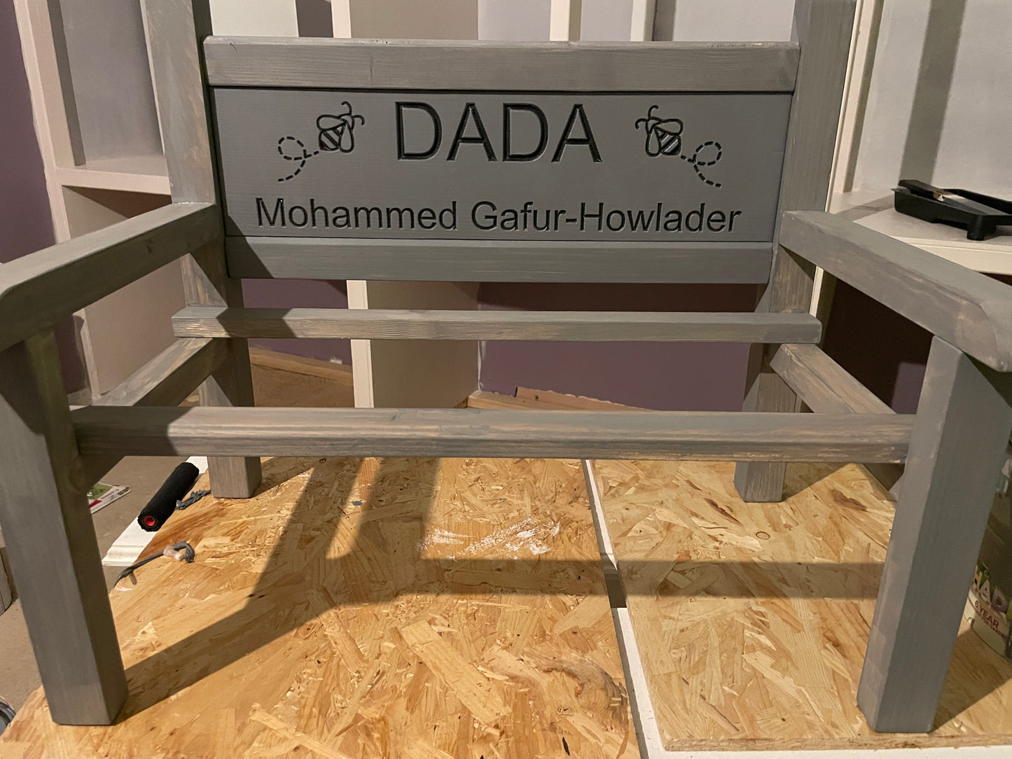 A custom painted wooden flower bench with a grey painted finish and with personalised wording and images